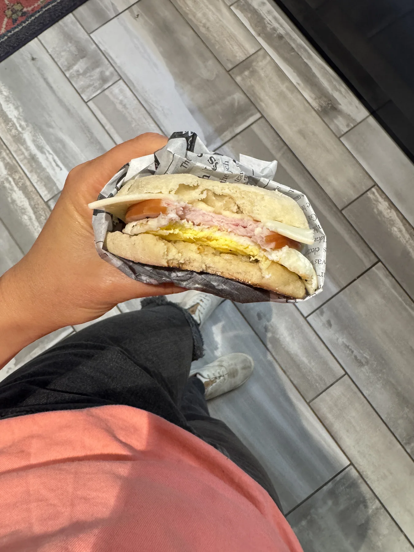 Hand holding a breakfast sandwich