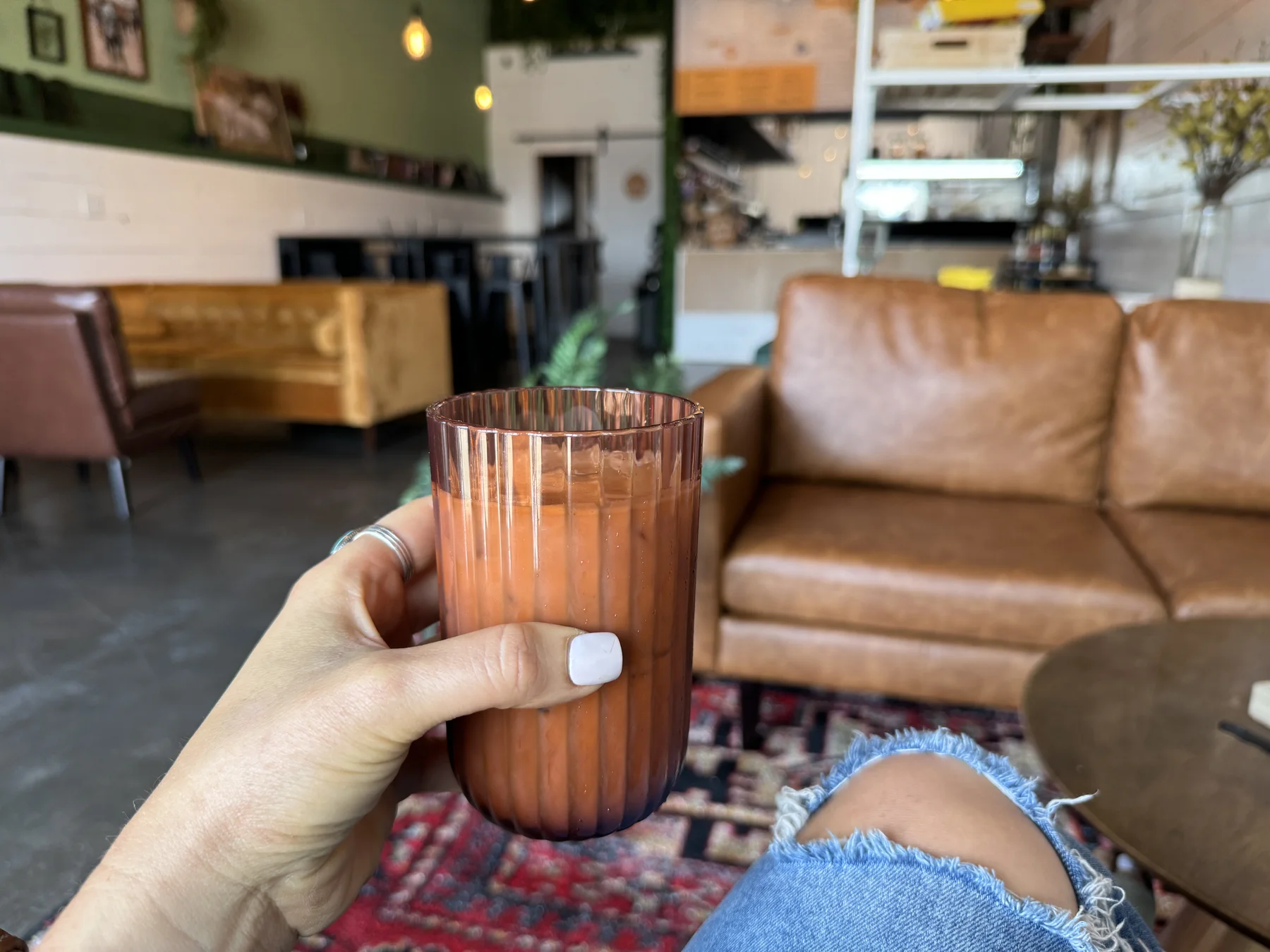 Iced drink in a glass with lounge seating in the background
